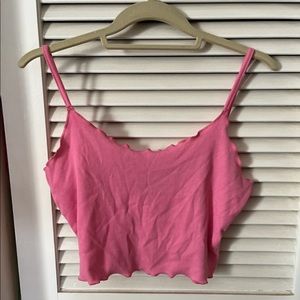 Pink ribbed crop top with ruffles on top and bottom.